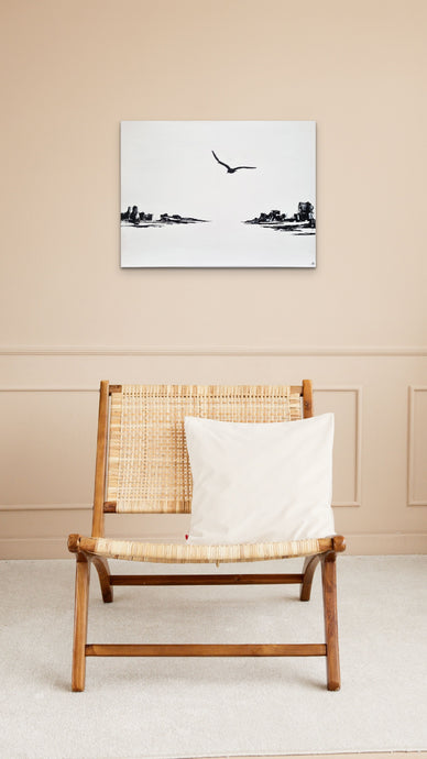 Tableau noir et blanc au dessus d'un fauteuil en bois